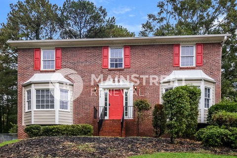 an old brick building with a red door and red windows