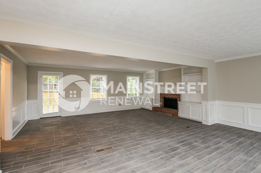 a living room with a wood floor and a fireplace