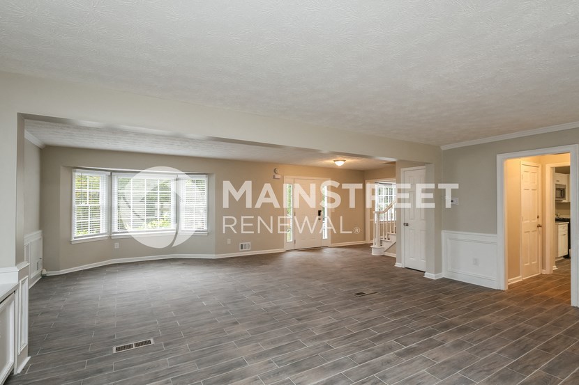 a living room with a hard wood floor and a large window