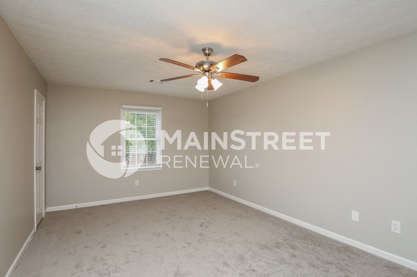 a bedroom with carpet and a ceiling fan