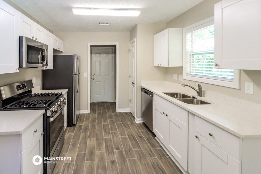 a kitchen with white cabinets and a sink and a stove and a refrigerator