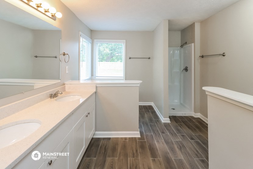 an empty bathroom with two sinks and a shower