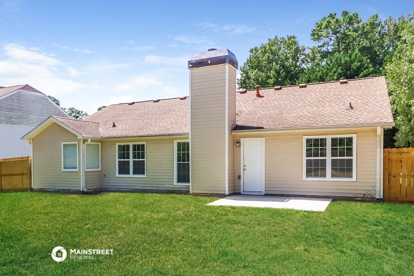 a cream colored house with a chimney on the side of it