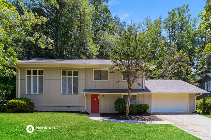 a cream colored house with a tree in front of it