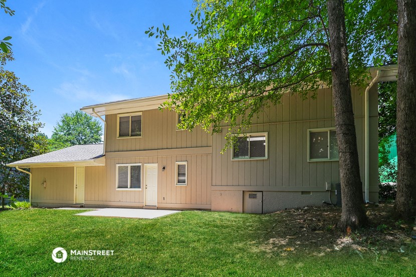 a yellow house with a tree in front of it