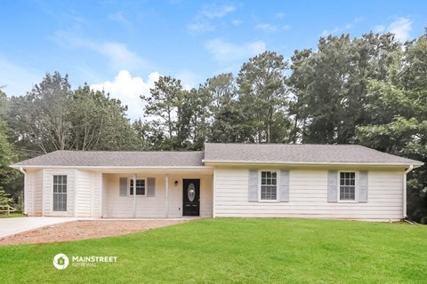 a white house with a green lawn and trees