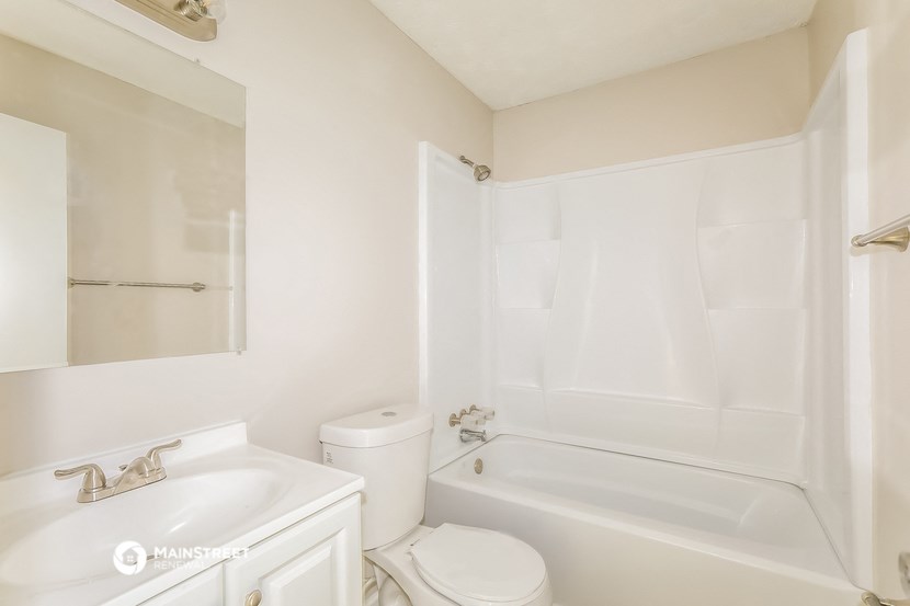 a white bathroom with a tub and a toilet and a sink