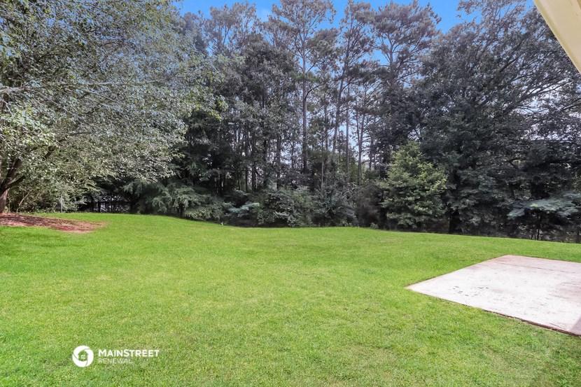 a backyard with a grass lawn and trees