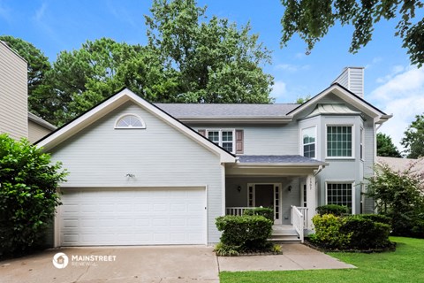 a white house with a white garage door and a lawn