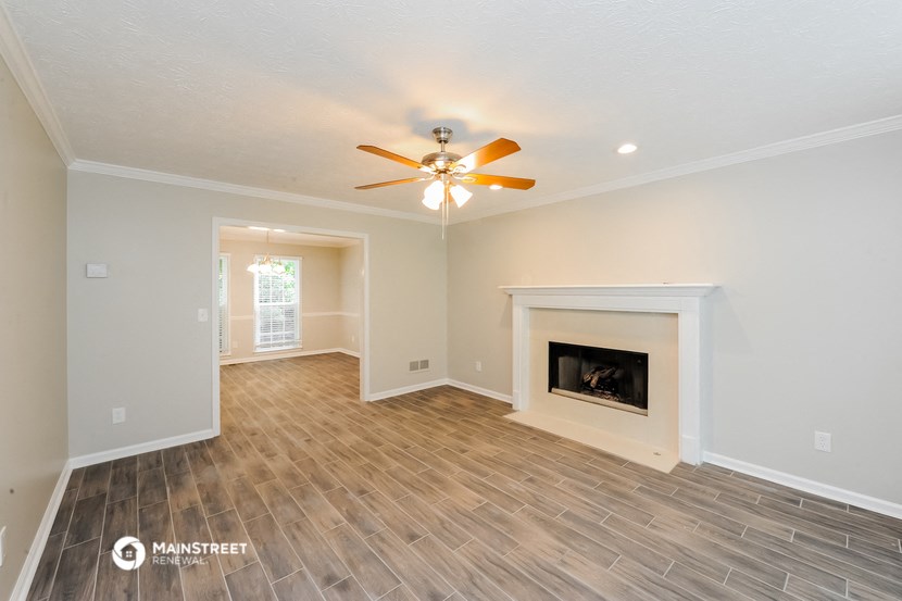 a living room with a fireplace and a ceiling fan