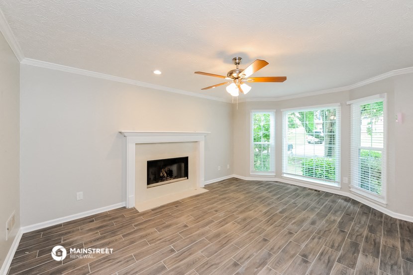 a living room with a fireplace and a ceiling fan