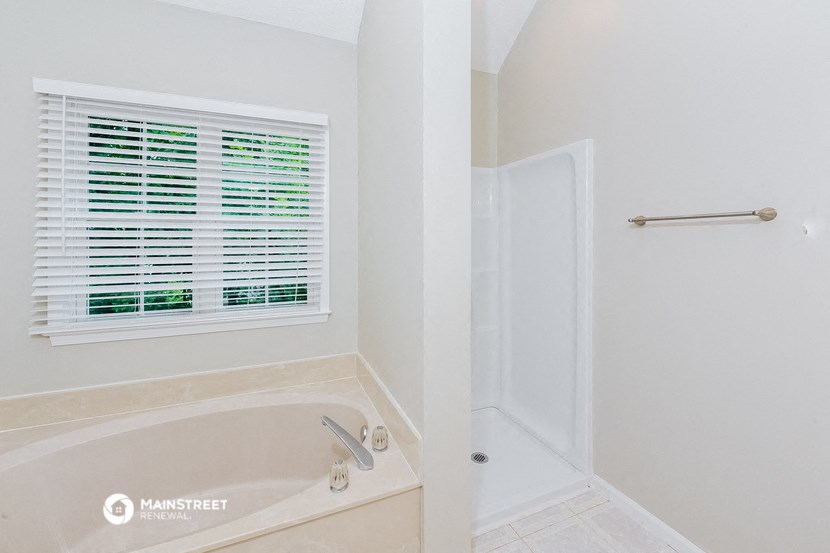 a bathroom with a tub and a shower and a window