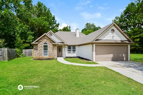 a small white house with a lawn and a driveway