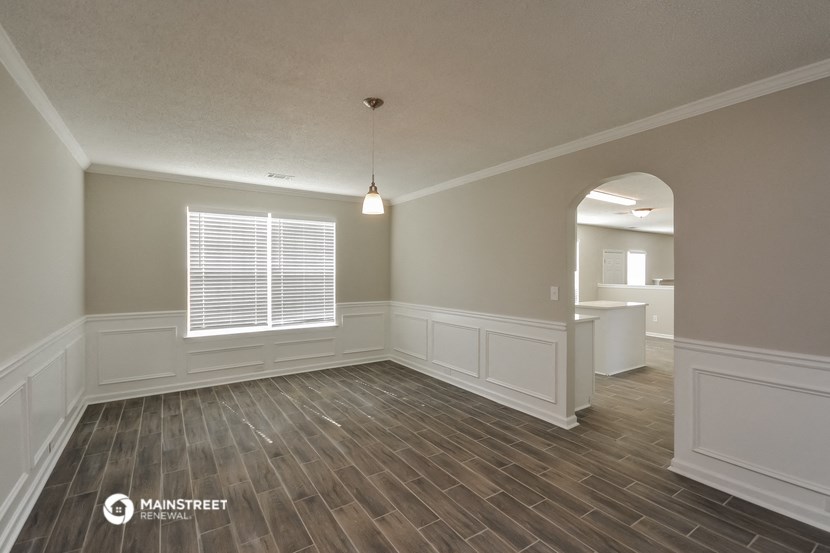 an empty living room with wood flooring and a large window