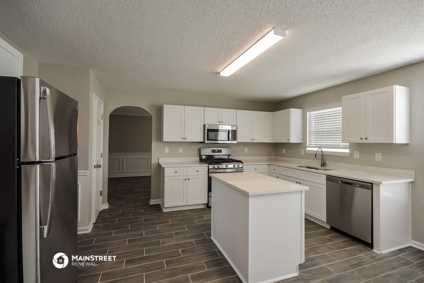 a kitchen with white cabinets and stainless steel appliances