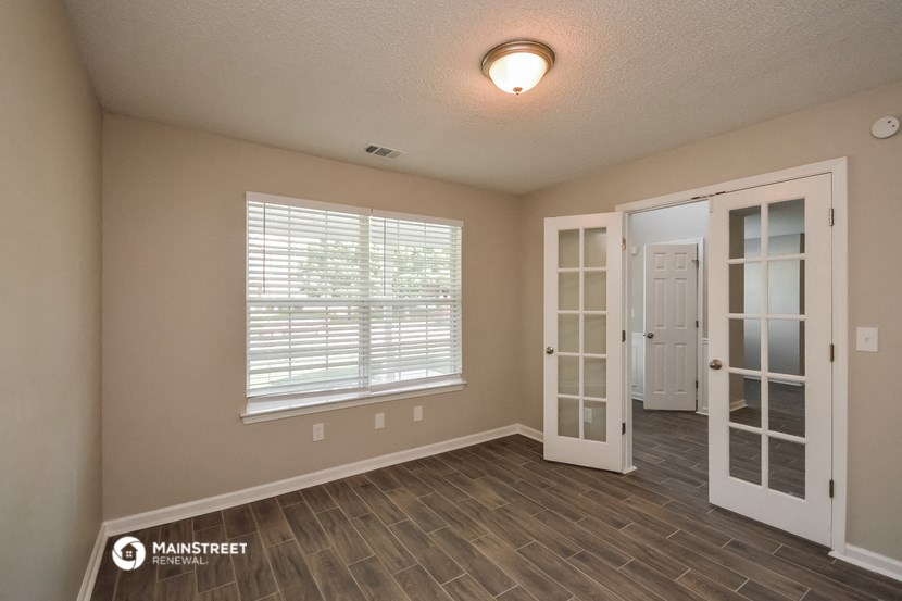 an empty living room with a door and a window