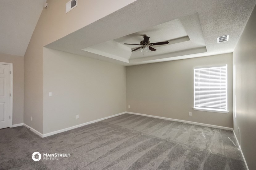 the living room of a home with a ceiling fan