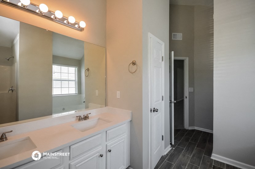 a bathroom with a sink and a mirror and a door