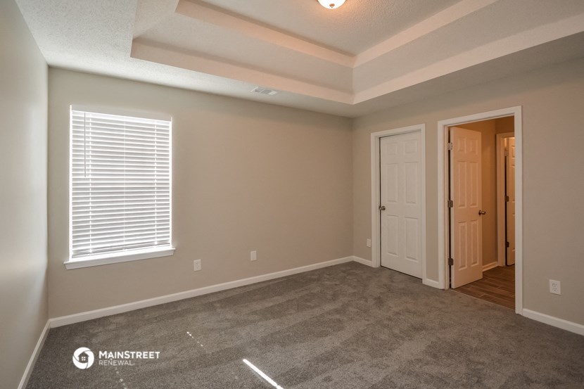 an empty living room with a door and a window