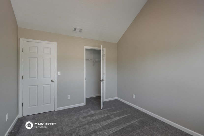 a bedroom with a closet and a white door