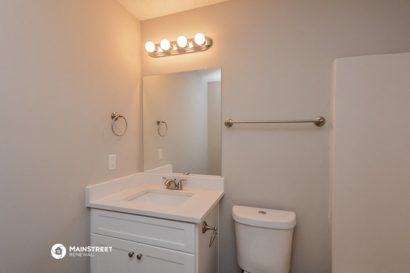 a white bathroom with a white sink and a toilet