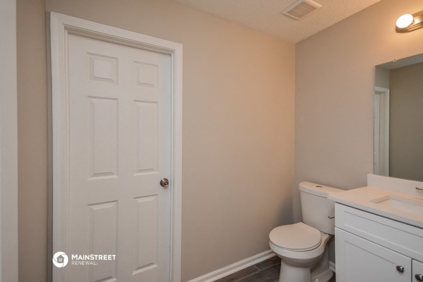 a bathroom with a white door and a toilet and a sink