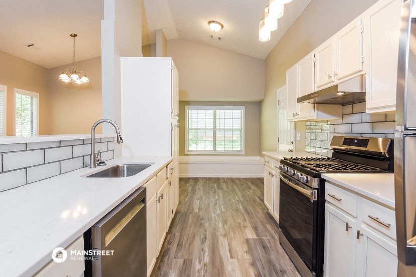 a kitchen with white cabinets and stainless steel appliances and a sink