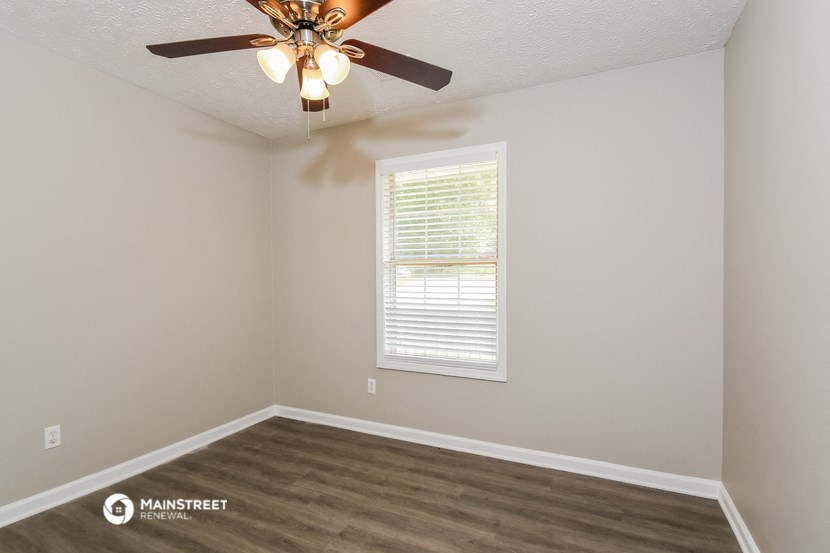 the interior of a bedroom with a ceiling fan and a window