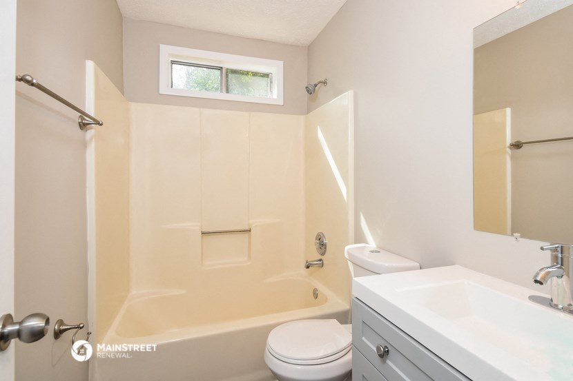 a bathroom with a tub and a sink and a toilet