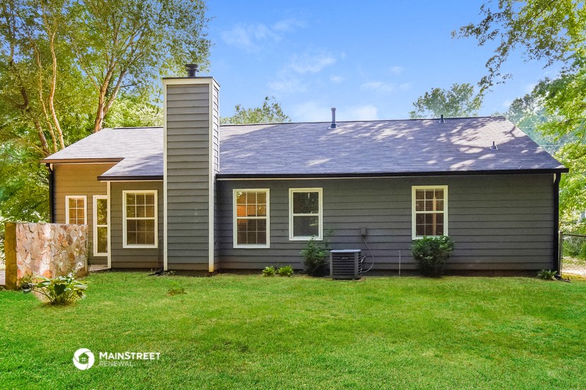 a gray house with a yard in front of it