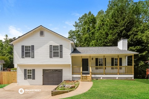 a white house with a porch and a lawn