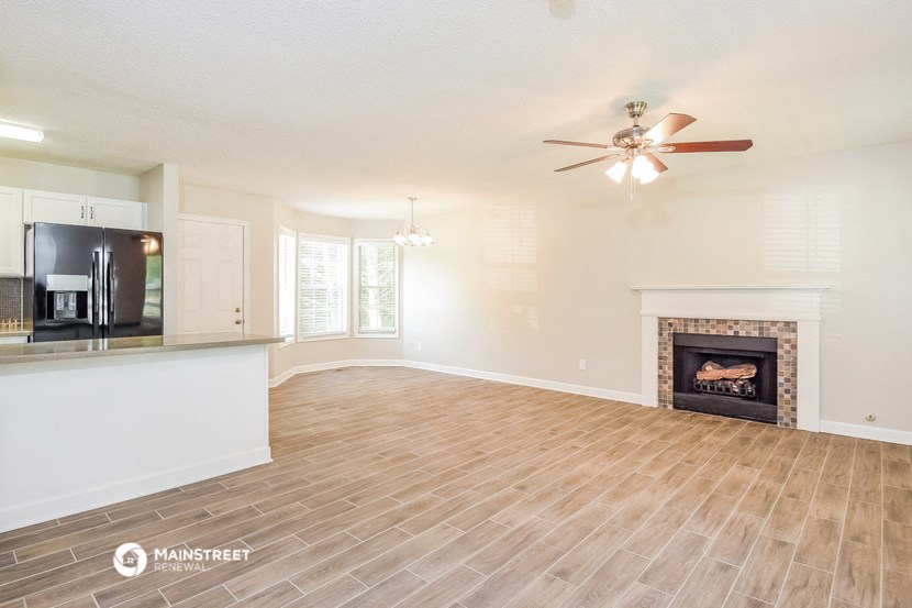 a living room with a fireplace and a ceiling fan