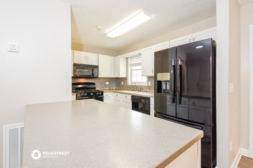 a kitchen with black appliances and white counter tops