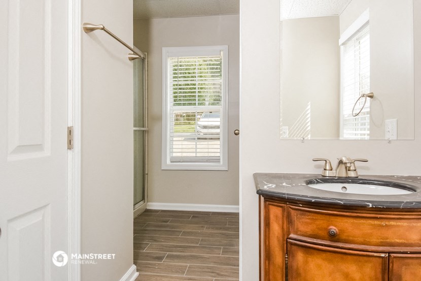 a bathroom with a sink and a shower and a mirror