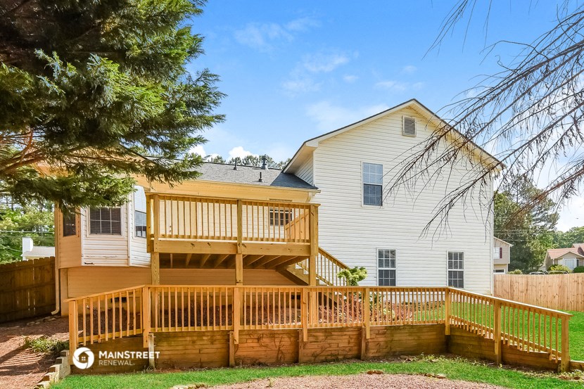 a deck in front of a house with a wooden fence