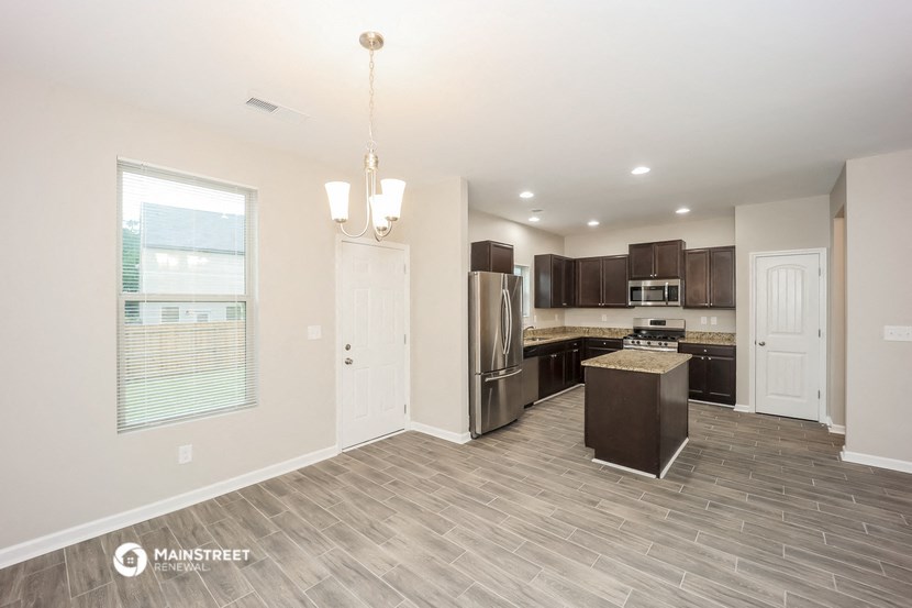 the kitchen and living room of a new home with a large window