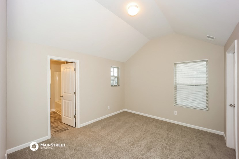 the upstairs bedroom with carpet and a door to the hallway