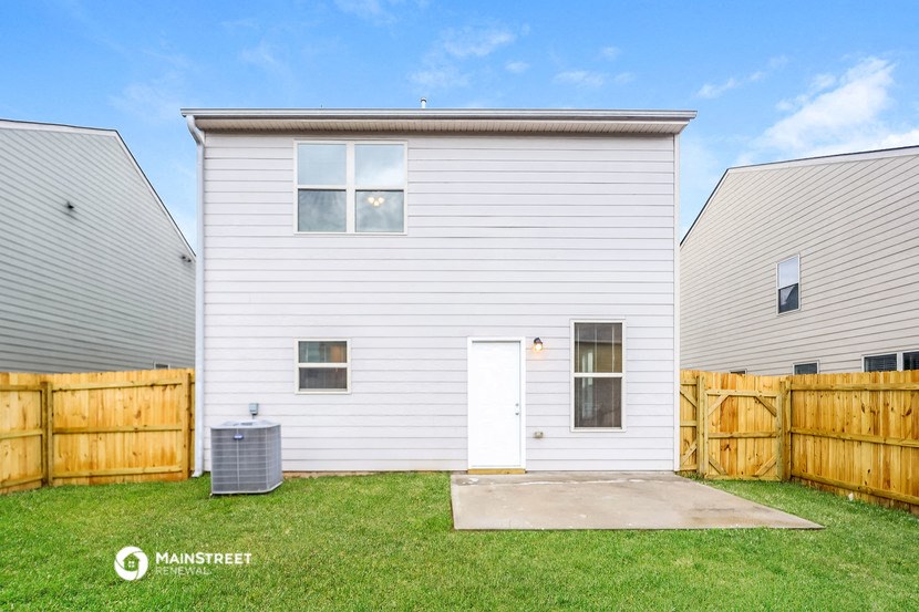 a white house with a yard and a wooden fence