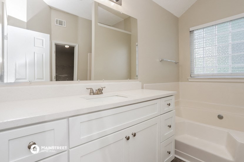 a bathroom with a sink and a mirror and a tub