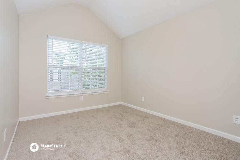 a bedroom with a carpeted floor and a window
