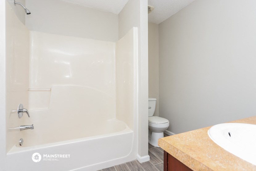 a bathroom with a tub and a toilet and a sink