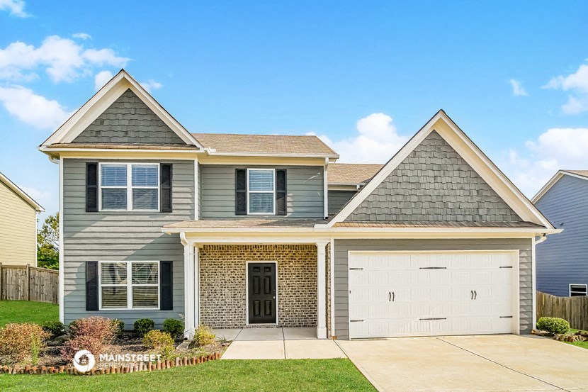 a house with two garage doors and a lawn