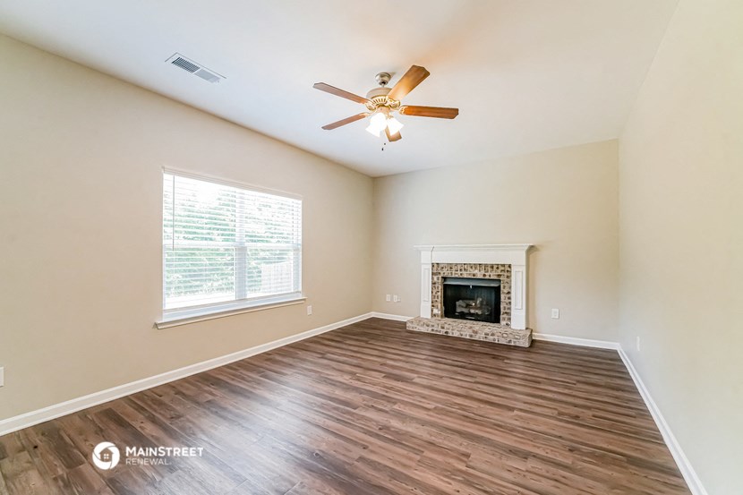 a living room with a fireplace and a ceiling fan