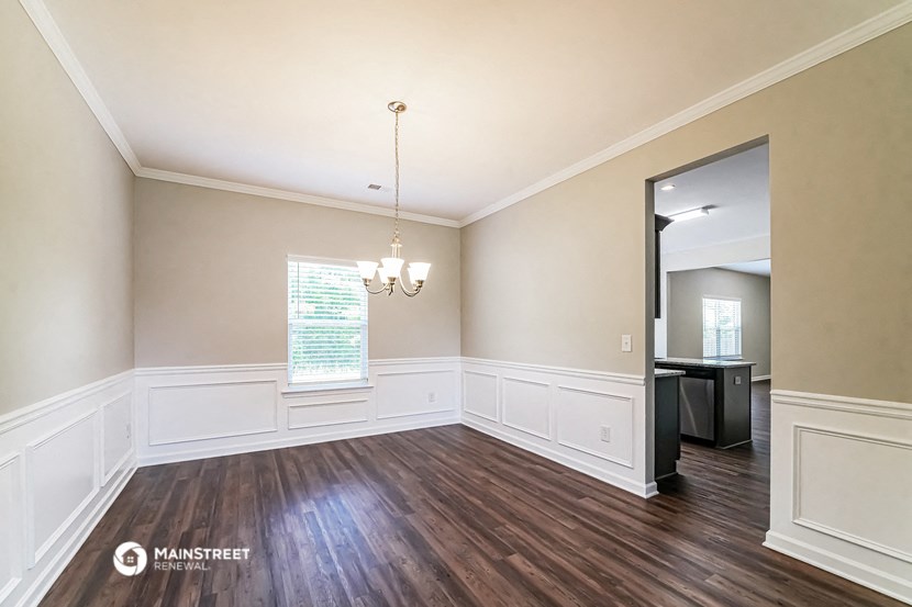 an empty living room with wood flooring and white walls