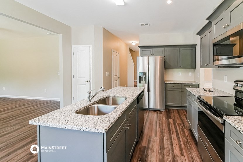 a large kitchen with stainless steel appliances and granite counter tops