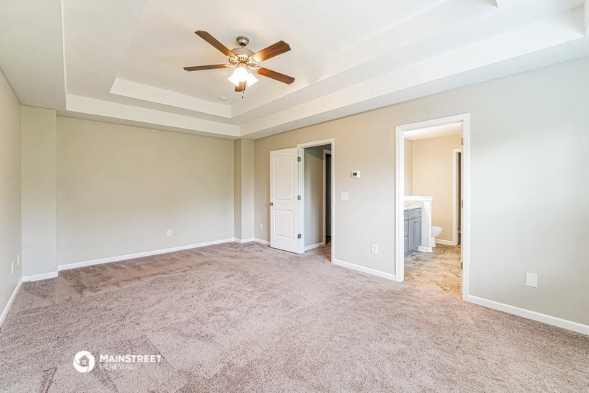 an empty living room with a ceiling fan