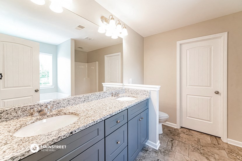 a blue and white bathroom with two sinks and a toilet