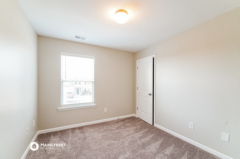 an empty room with a door and a window