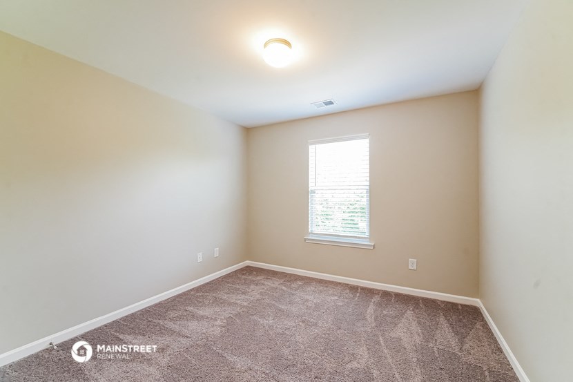 an empty room with carpet and a window
