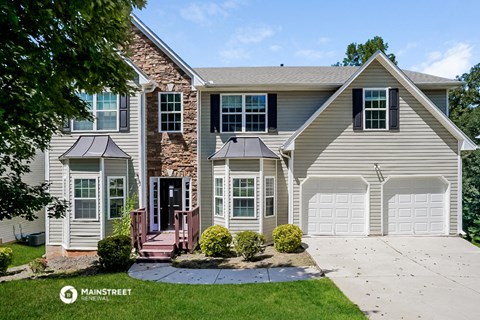 a white house with a white garage door and a driveway